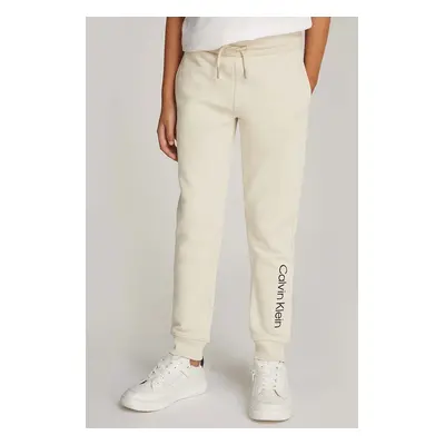 Dětské bavlněné tepláky Calvin Klein Jeans REGULAR JOGGER béžová barva, s potiskem, IU0IU00681